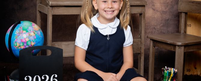 a little girl in agrey pinafore dress at photo shoot