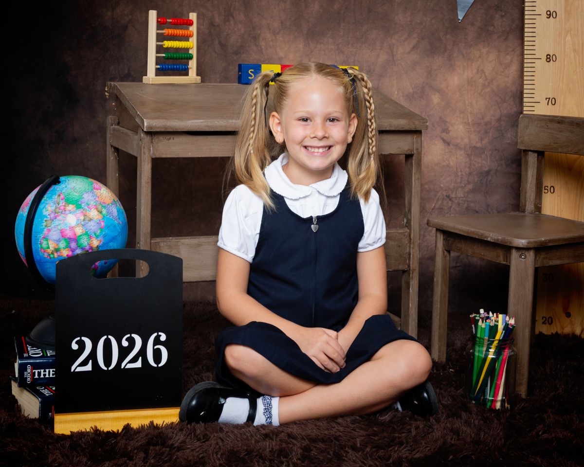 a little girl in agrey pinafore dress at photo shoot