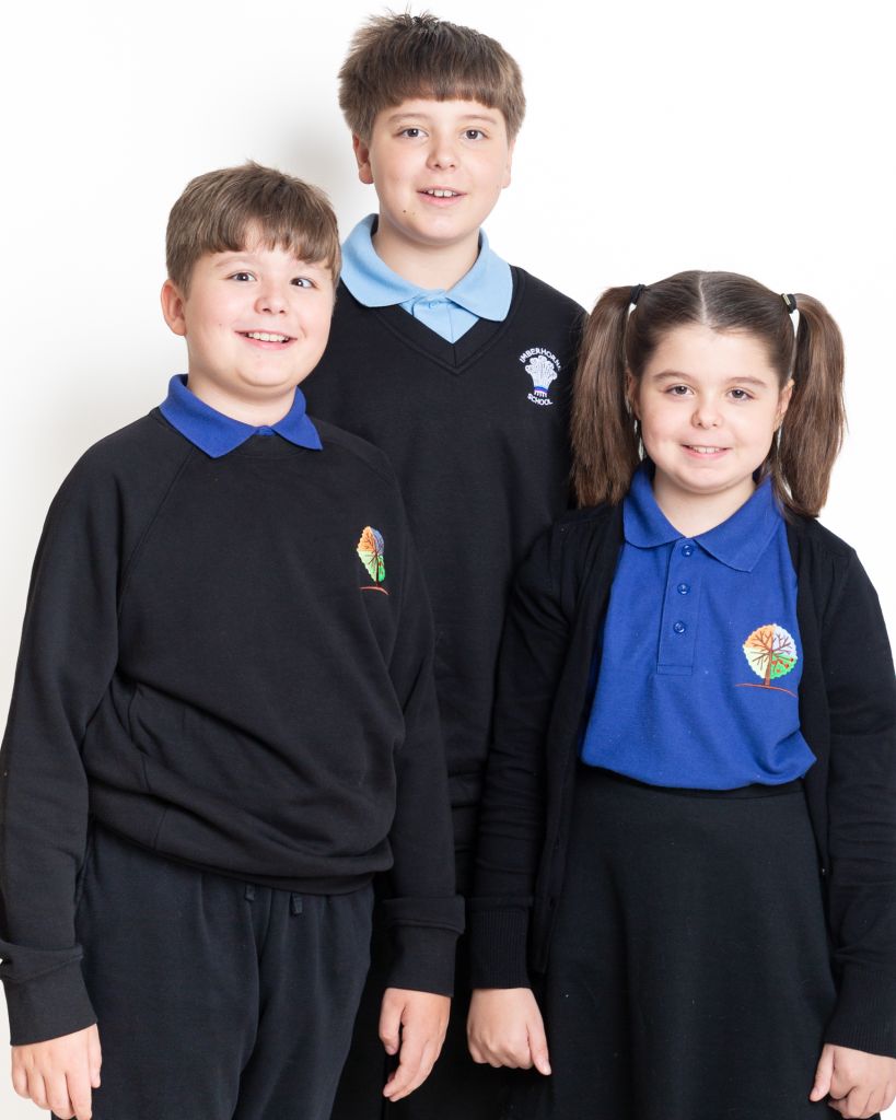 Twins and their older brother pose for a school photo in West Sussex photo studio